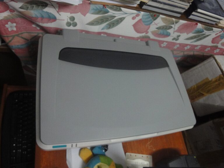 Closed flatbed scanner on a desk beside a keyboard