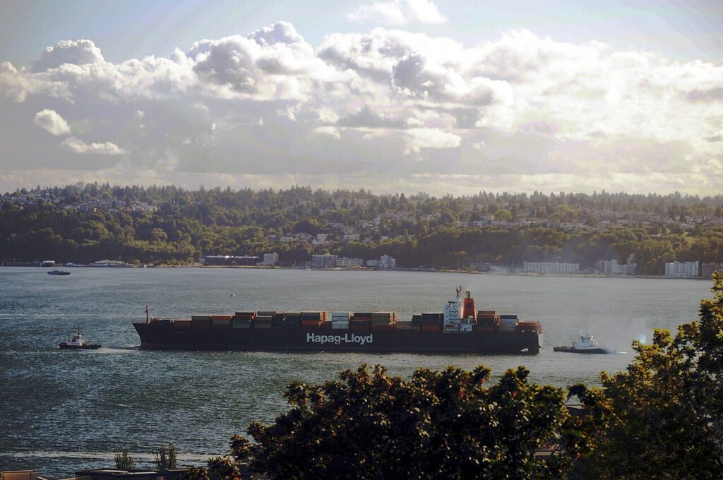 Hapag-Lloyd container ship and two tugboats on Elliott Bay