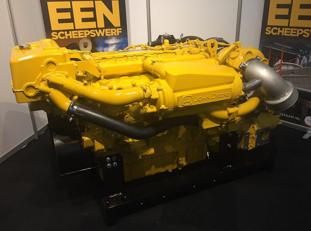 Yellow John Deere marine diesel engine displayed on a stand
