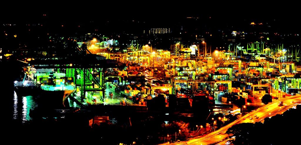 Container cranes and ships at Tanjong Pagar terminal in Singapore at night