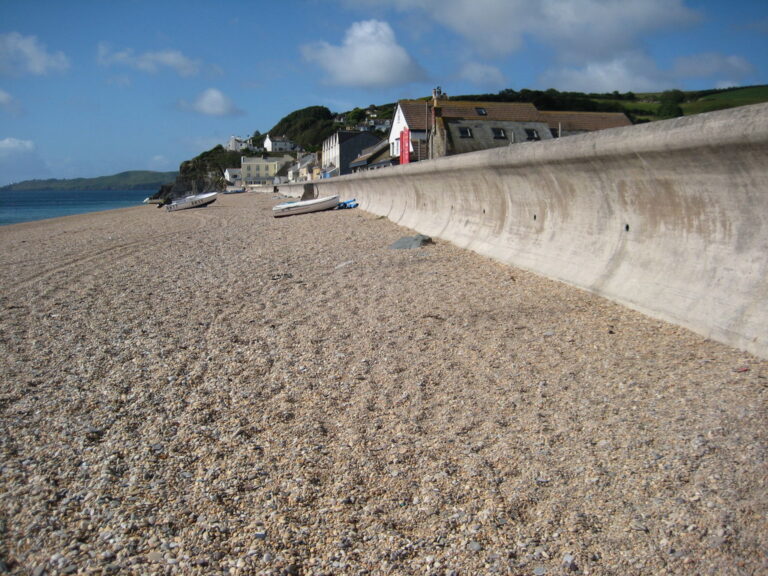 Shingle beach beside the sea wall and houses at Torcross